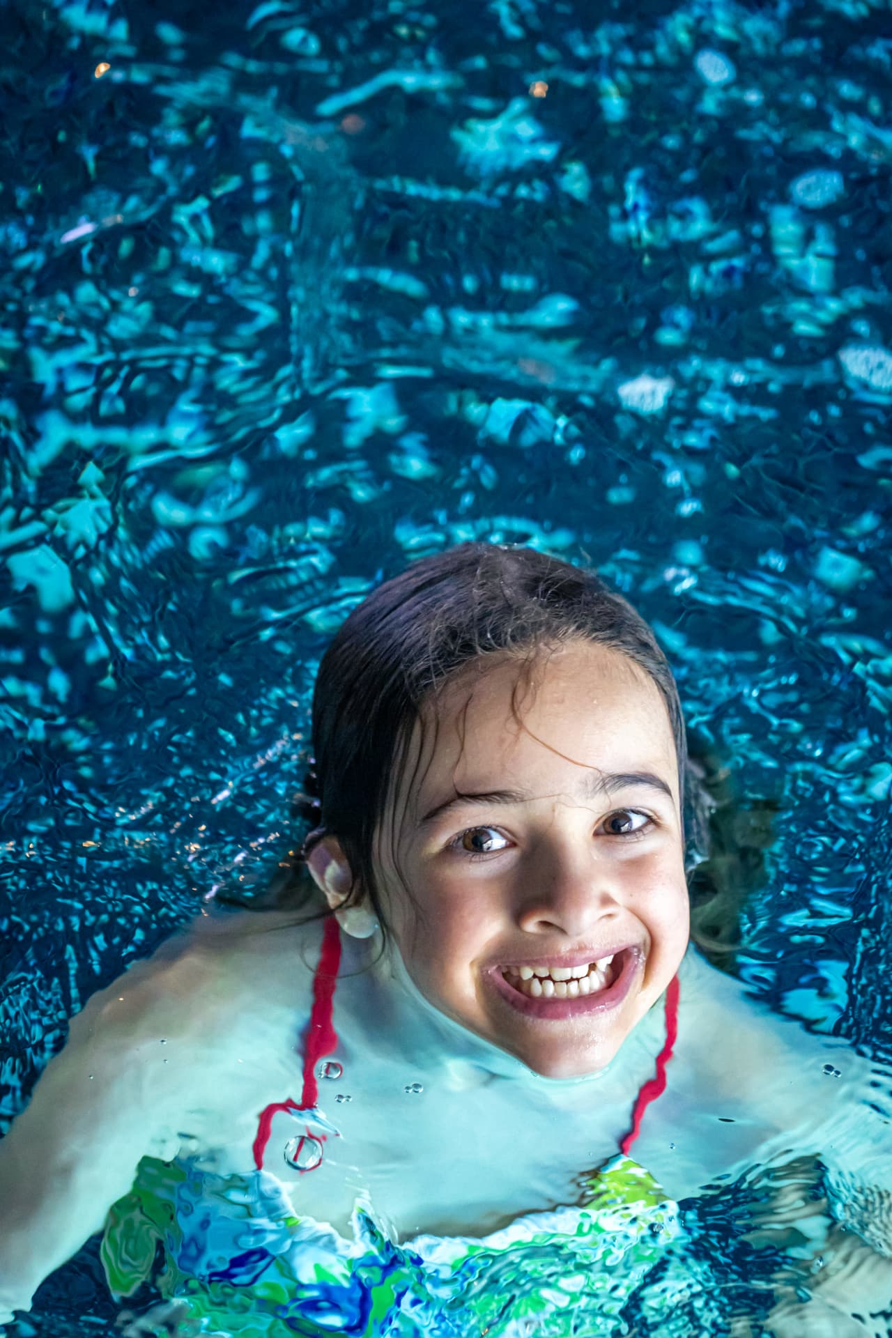 Smiling child swimming confidently underwater